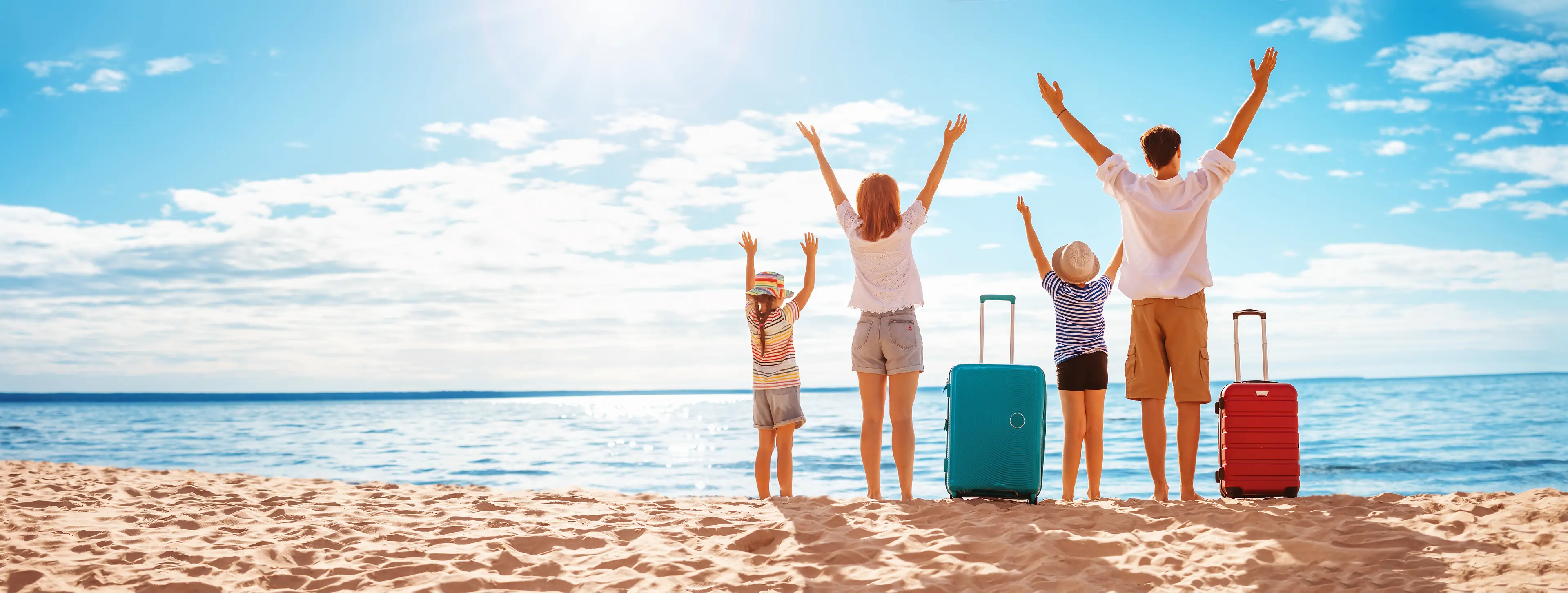Mother and father with their children standing on the beach with suitcases. Concept of the family vacation and tourism.